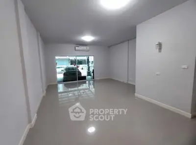 Spacious empty room with glossy floors and large window, ideal for customization.