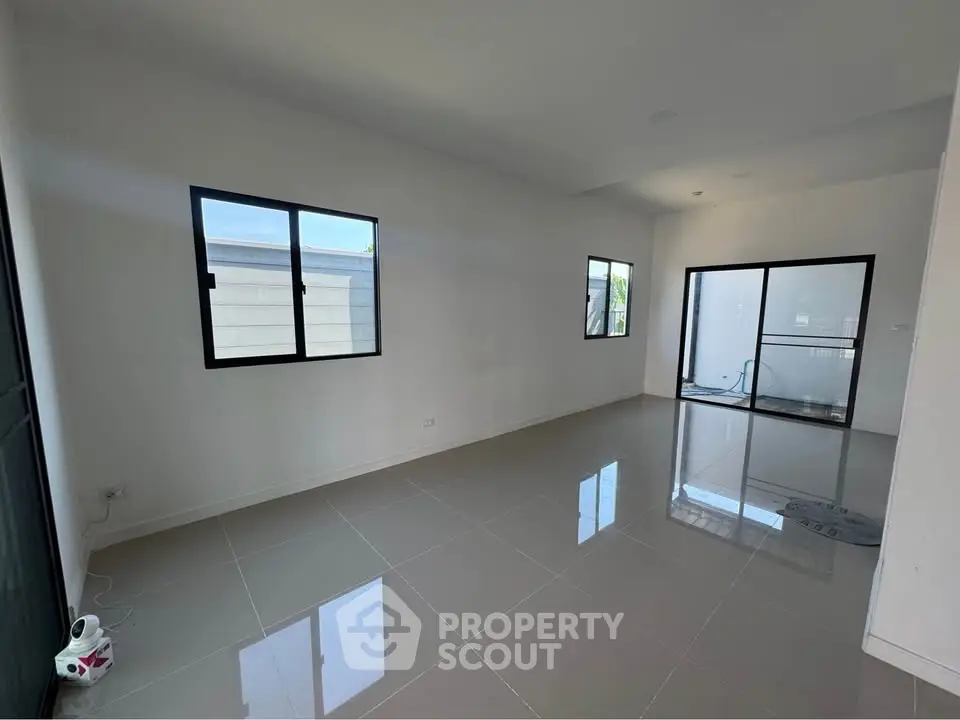 Spacious modern living room with large windows and glossy tiled floors