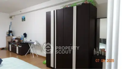 Spacious bedroom with modern dark wood furniture and ample storage space.