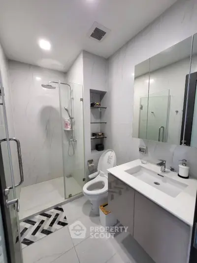 Modern bathroom with glass shower and sleek vanity in luxury apartment