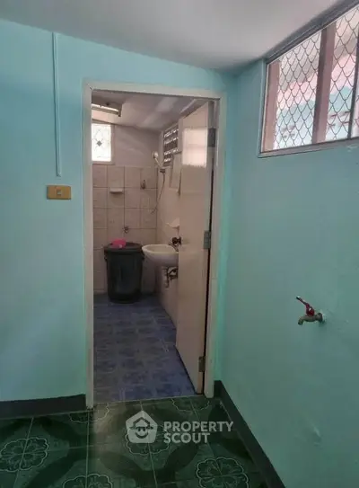 Compact bathroom with blue tiles and small sink in cozy home