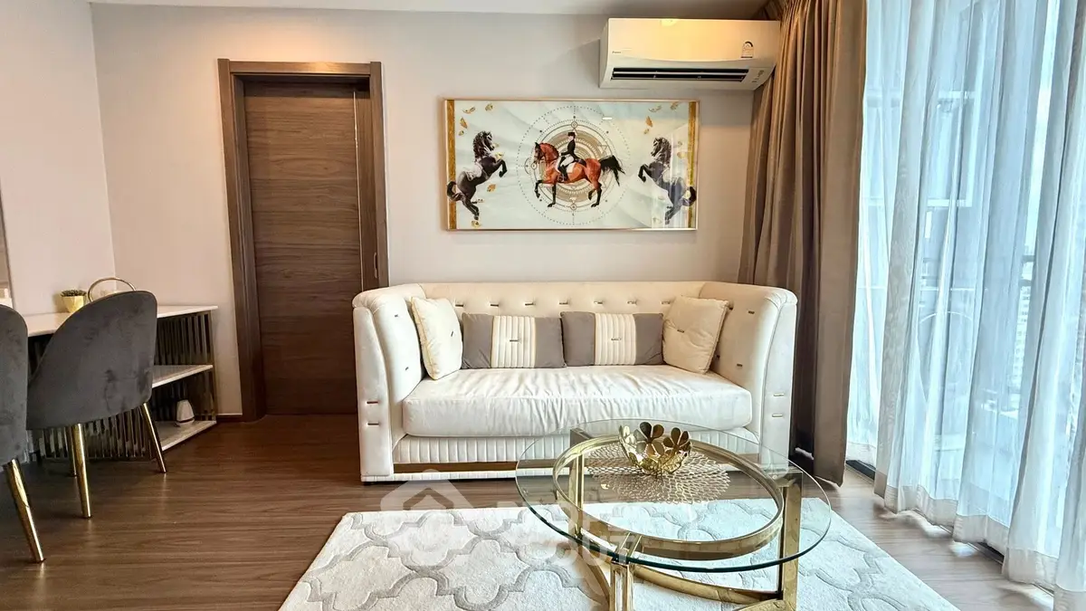 Elegant living room with plush sofa, modern decor, and natural light from large windows.