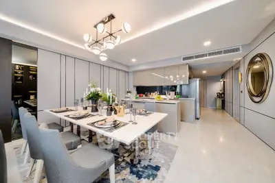 Luxurious open-plan dining and kitchen area with modern decor and elegant lighting.