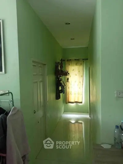Bright hallway with green walls and a window with yellow curtains