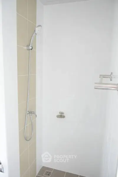 Modern minimalist shower area with sleek fixtures and neutral tiles
