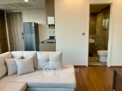 Modern open-plan living room with sleek kitchen and cozy sofa