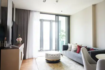 Modern living room with elegant decor and large windows offering natural light.