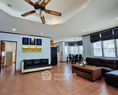 Spacious living room with modern furniture and ceiling fan in a bright, open layout.
