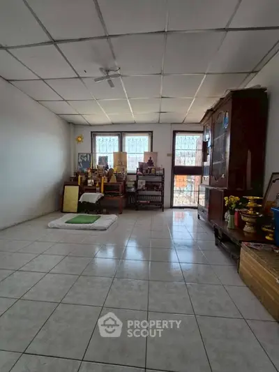 Spacious room with tiled floor and large windows, ideal for versatile use in a serene setting.