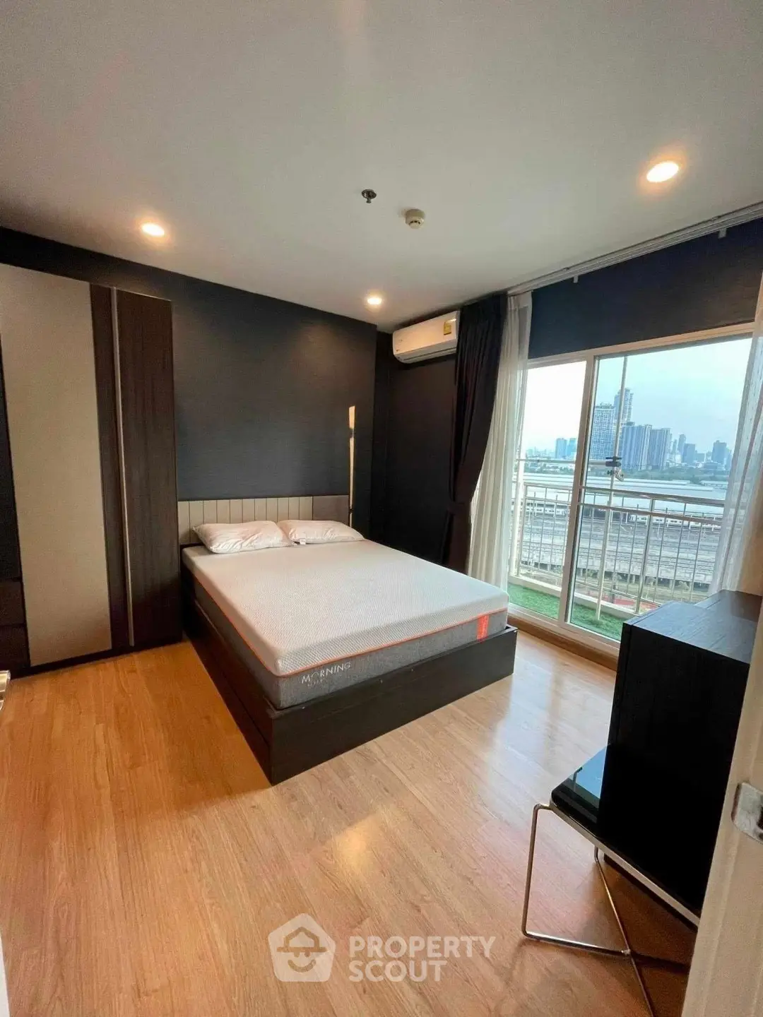 Modern bedroom with city view and sleek furnishings in high-rise apartment