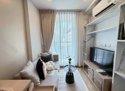 Modern living room with stylish decor, large window, and air conditioning unit.