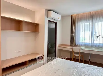 Modern bedroom with built-in shelves, desk, and air conditioning, perfect for comfortable living.