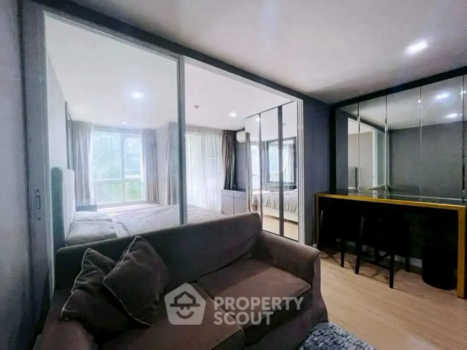 Modern apartment interior with cozy living area and bedroom, featuring large windows and stylish decor.