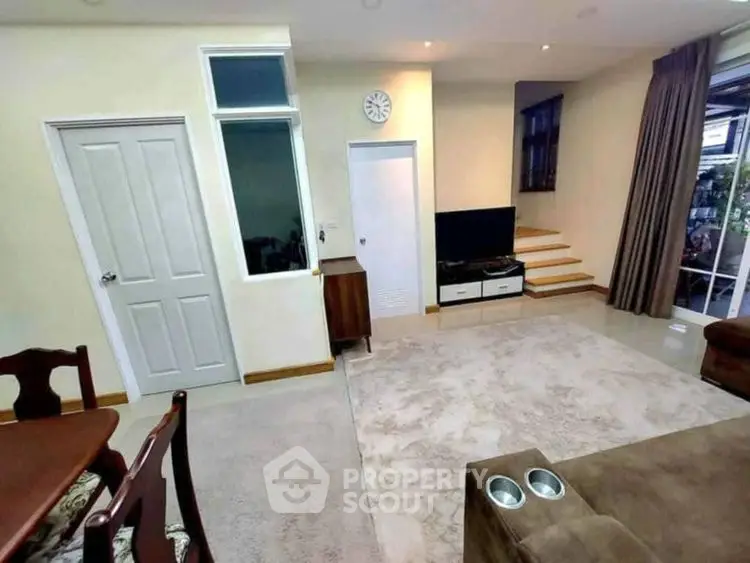 Spacious living room with modern decor and cozy seating area.