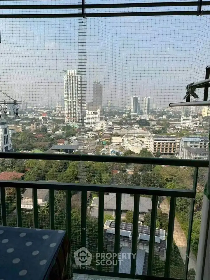 Stunning cityscape view from a high-rise balcony with safety netting, perfect for urban living.