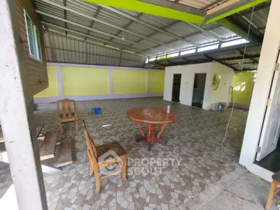 Spacious open area with tiled floor and rustic wooden furniture, ideal for versatile use.