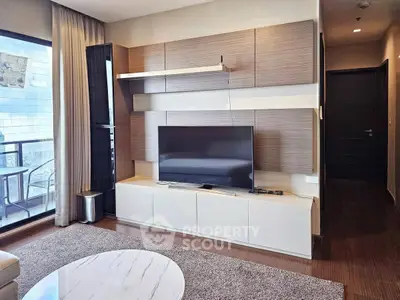 Modern living room with sleek TV unit and balcony view in luxury apartment.