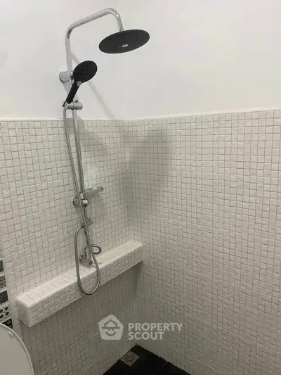 Modern bathroom with sleek shower fixtures and tiled walls.