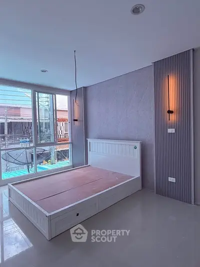 Spacious bedroom with modern design and large windows offering natural light.