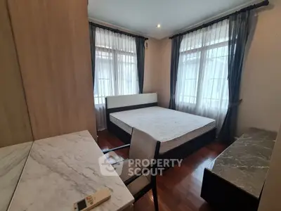 Spacious bedroom with elegant marble furniture and large windows for natural light.