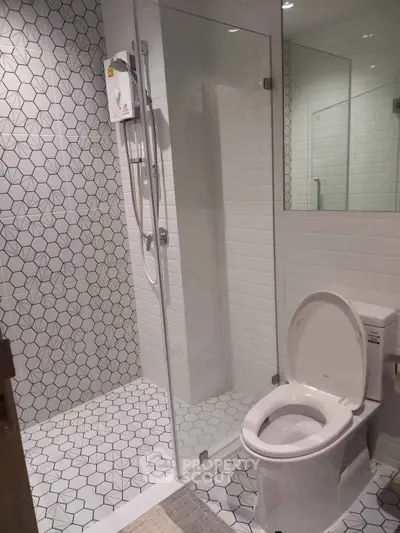 Modern bathroom with geometric tile design and glass shower enclosure