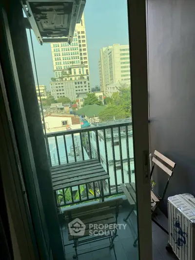Charming city view from a cozy balcony with seating area, perfect for relaxation.