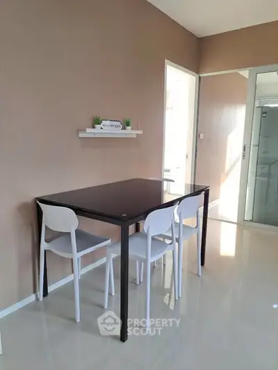 Modern dining area with sleek table and chairs in a bright, minimalist interior.