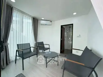 Modern living room with sleek furniture and large windows for natural light.