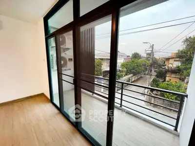 Spacious balcony with sliding glass doors and urban view, perfect for relaxation.