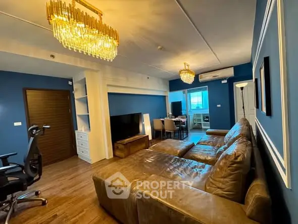 Luxurious living room with elegant chandeliers and plush leather seating