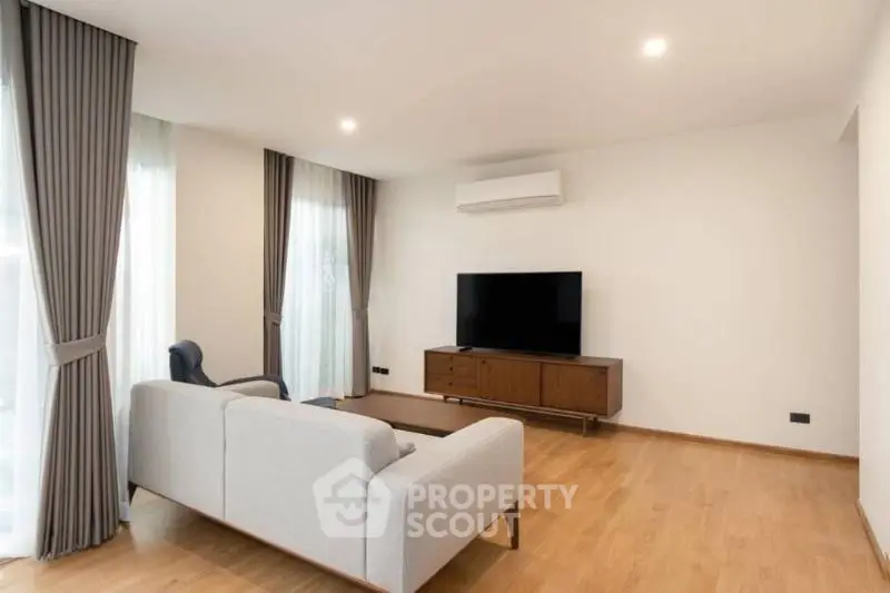 Modern living room with sleek furniture and large windows for natural light.