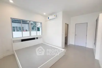 Modern minimalist bedroom with large windows and air conditioning