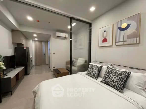 Modern bedroom with stylish decor and open layout connecting to a compact kitchen area.