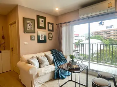 Cozy living room with balcony view, featuring a comfortable sofa and stylish decor.