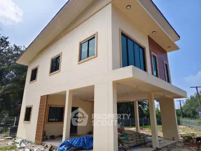 Modern two-story house with large windows and spacious outdoor area, perfect for family living.