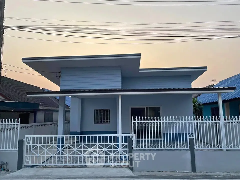 Modern single-story house with sleek design and gated entrance in a suburban neighborhood.