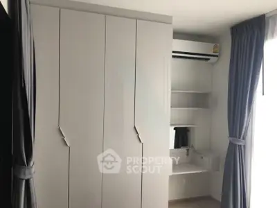 Modern bedroom with sleek wardrobe and air conditioning unit