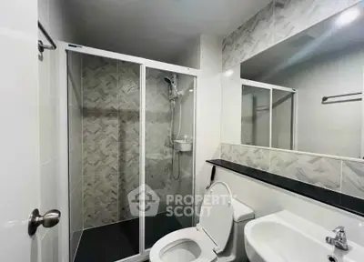 Modern bathroom with glass shower enclosure and sleek fixtures