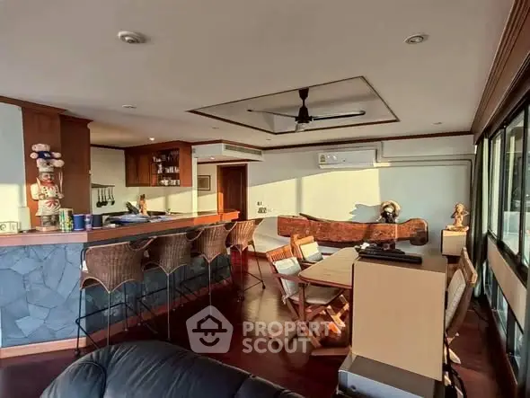 Spacious living room with bar and natural light, ideal for entertaining.