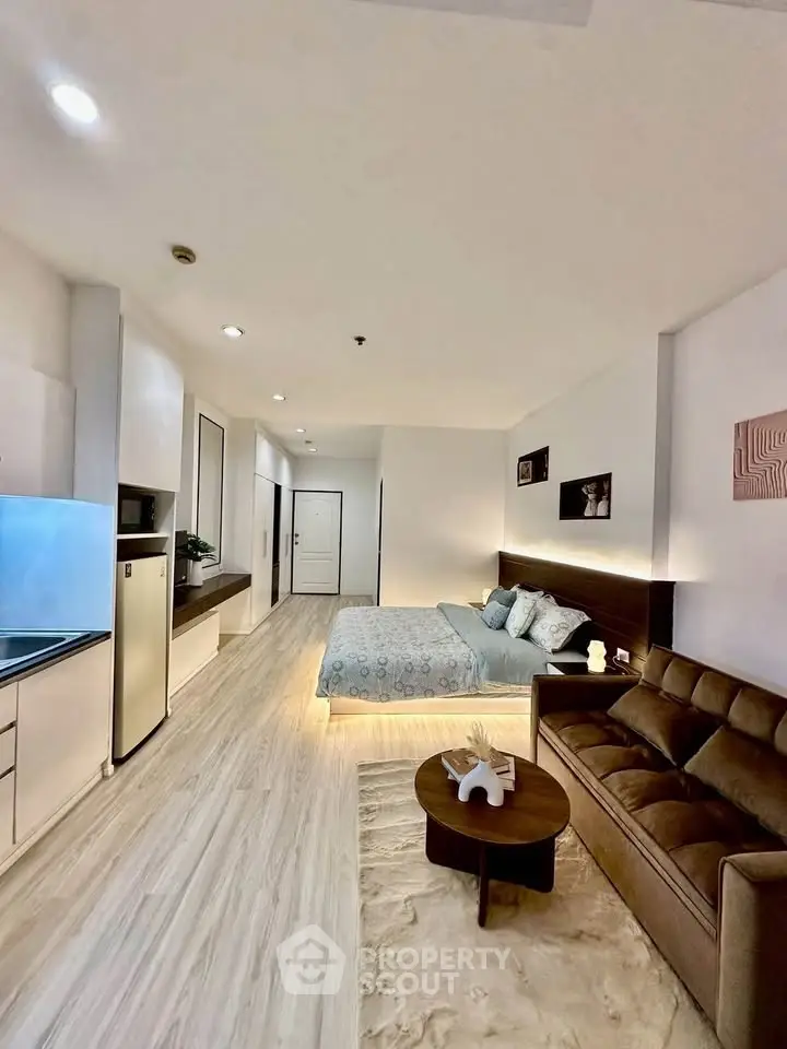 Modern studio apartment with stylish decor and open layout, featuring a cozy living area and sleek kitchen.