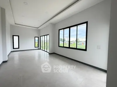 Spacious modern living room with large windows offering scenic views, perfect for natural light lovers.