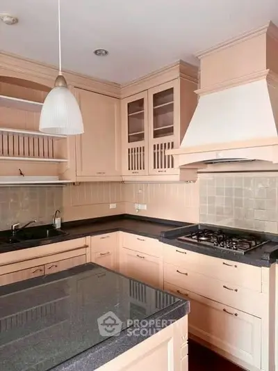 Elegant kitchen with modern gas stove and ample cabinetry in a stylish home.