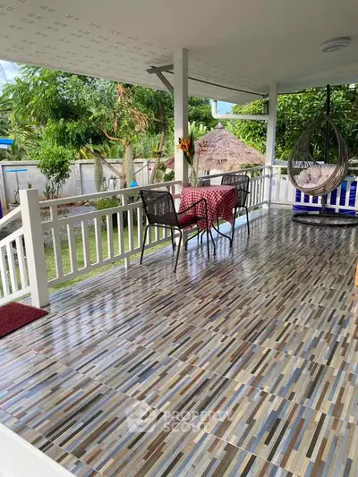 Charming balcony with stylish tiles and cozy seating overlooking lush garden.
