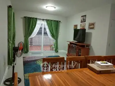 Cozy living room with wooden furniture and green curtains, perfect for family gatherings.