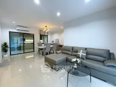 Spacious modern living room with elegant decor and open dining area, perfect for entertaining.