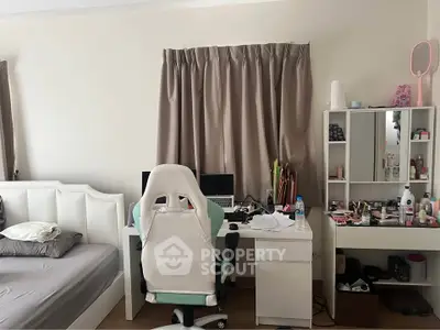 Cozy bedroom with study area featuring a desk, chair, and organized vanity space.
