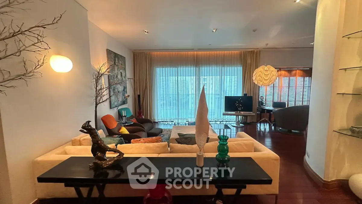 Luxurious living room with modern decor and floor-to-ceiling windows offering stunning city views.