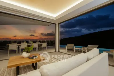 Luxurious living room with stunning sunset view and poolside seating.