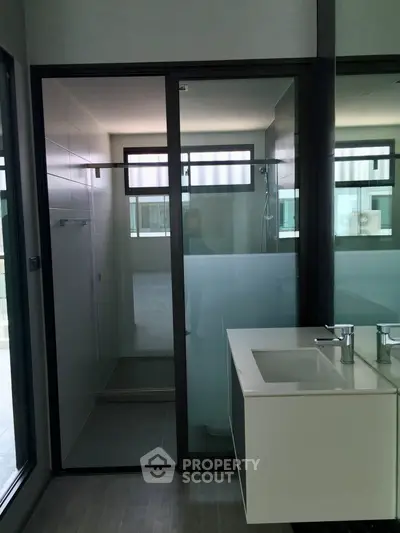 Modern bathroom with sleek glass shower and contemporary sink design.