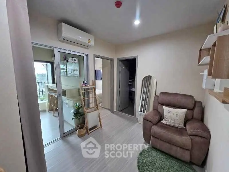 Cozy living room with modern decor and balcony access in a stylish apartment.